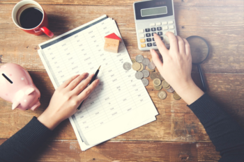 A woman accountant counting financial statement with the help of a calculator.