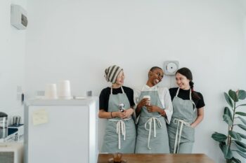 Startup coffee house workers smiling enjoying a drink, chatting about the Mini Budget 2022