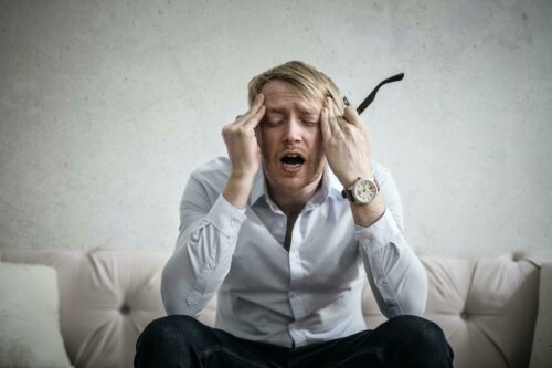 Man with head in his hands screaming