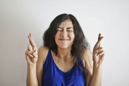 Woman crossing her fingers hoping she won't get a tax audit in 2023