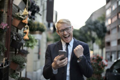 Business man on phone excited about R&D tax relief coming in