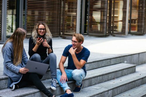 3 people having a casual meeting outside about their payroll app
