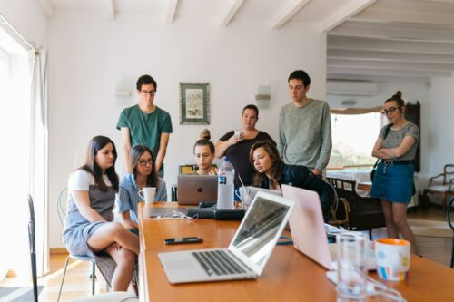 Group of people around laptop learning about new contract management automation