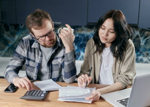 Two workers discussing invoicing as part of how to manage cashflow in a recession