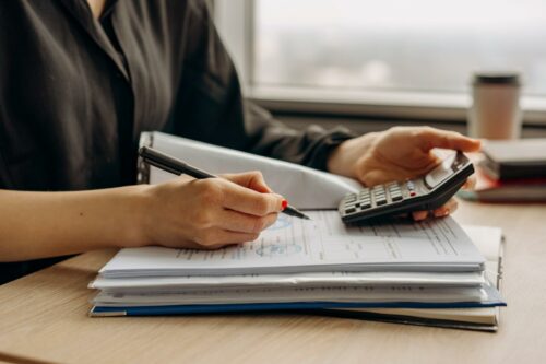Woman on calculator, working out her tax credits with the new R&D changes for April 2023