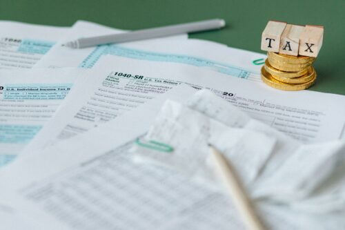 Blocks spelling out tax, laid above HMRC forms, to remind you about covid payment self assessment