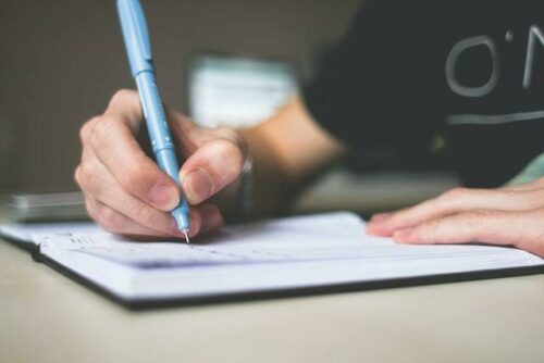 Close up of someone writing with a pen