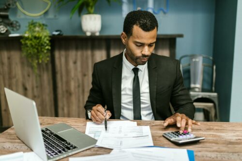 Man in black suit working out the r&d changes for April 2023